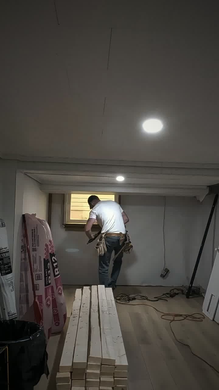 Cameron finishing trim work in a basement repaired after water damage