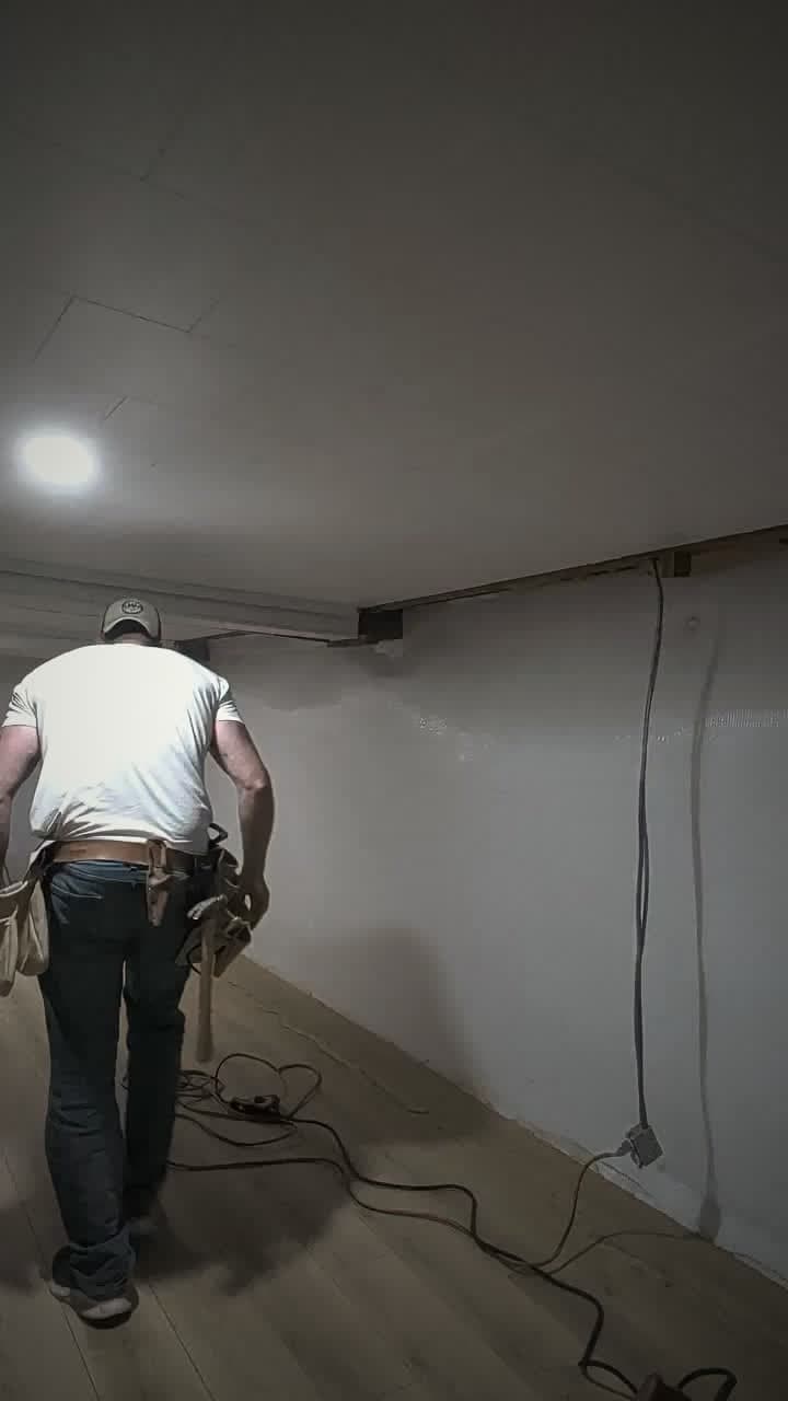 A basement left part-finished after water damage, with exposed wiring and no trim