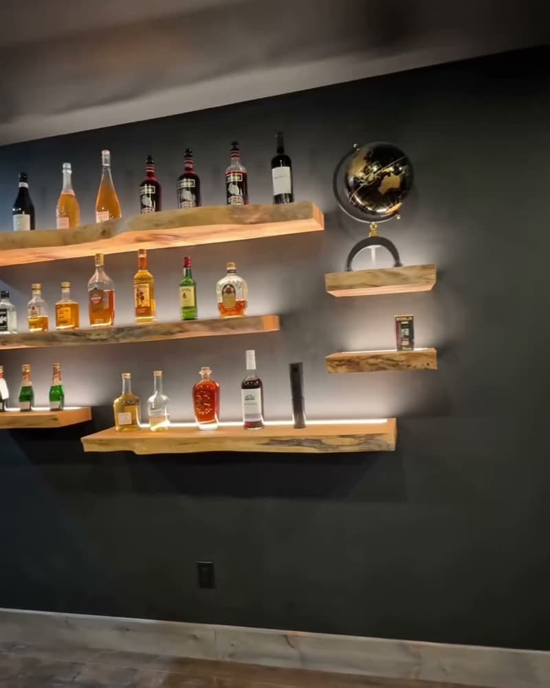 Backlit live-edge whisky shelves, milled and mounted by Hawthorn Construction