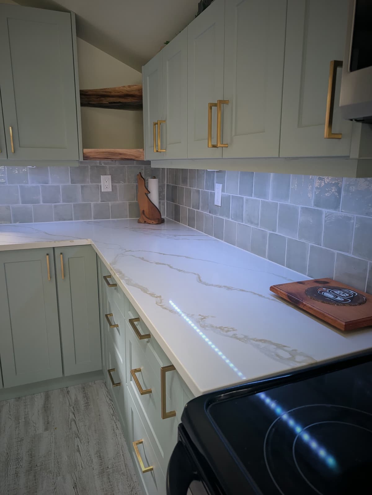 Quartz counter, grey subway backsplash, and brass cabinet hardware