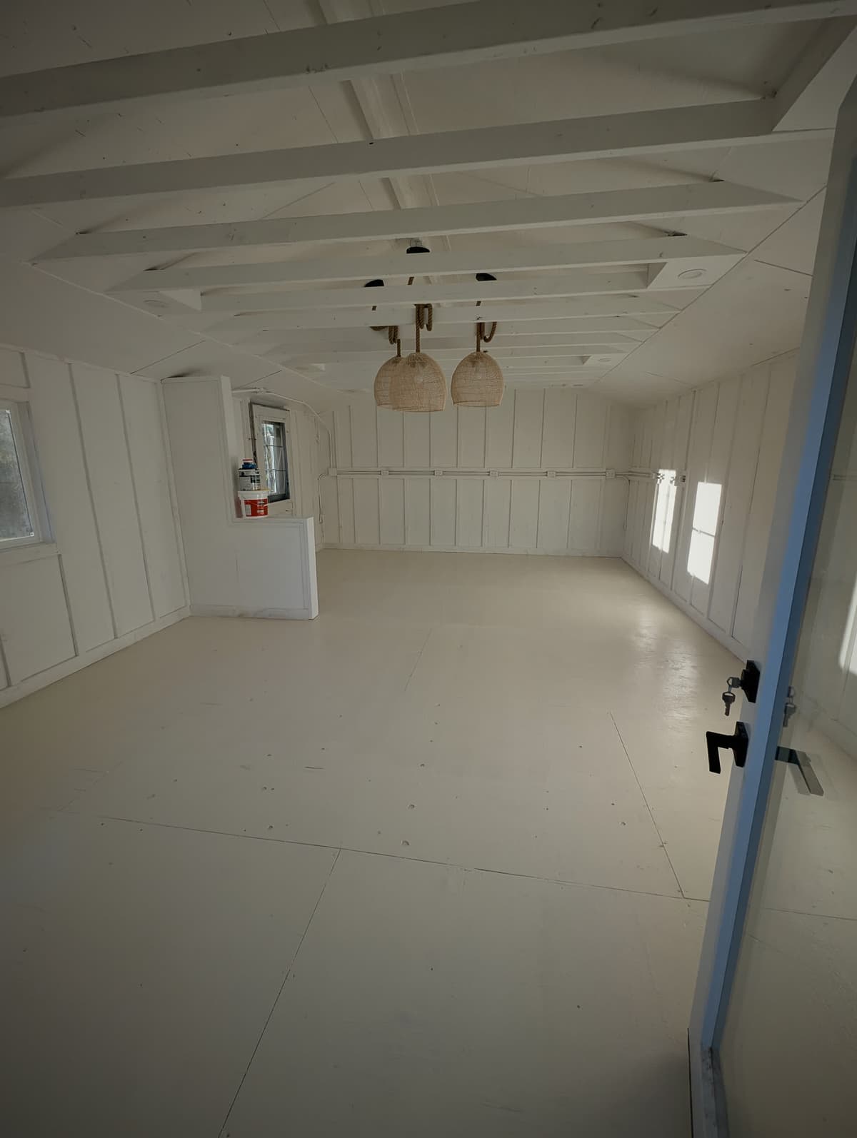 Renovated living space with a coffered white ceiling and rattan pendant lights